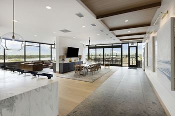 A modern living room with a large marble table and a long hallway.